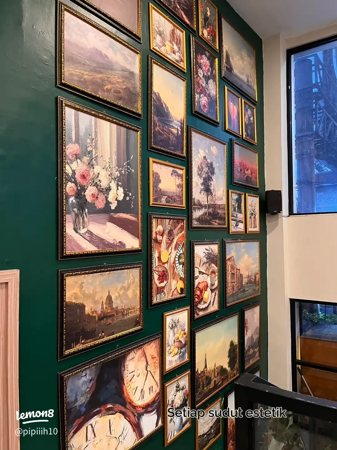 Dinding galeri Historia dengan bingkai karya seni dan panel hijau